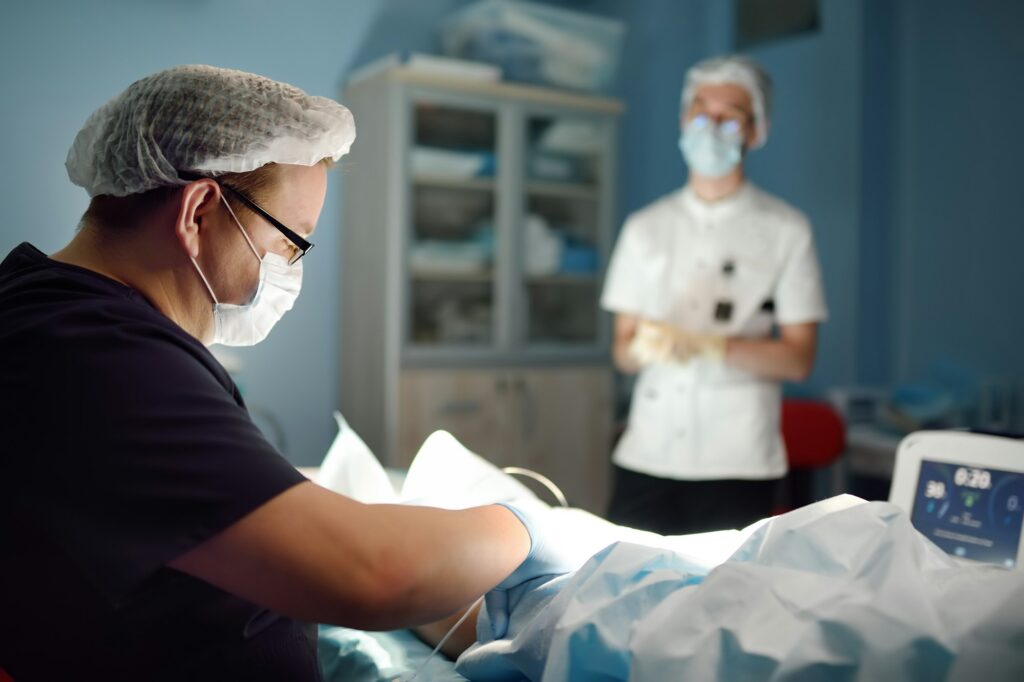 Professional vascular surgeon and assistant in the operating room of the clinic during vein surgery
